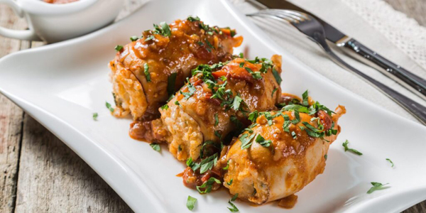 Рецепты: горячие блюда на праздничный стол на Новый год — 2026. Кальмары с рисом, запечённые в томатном соусе